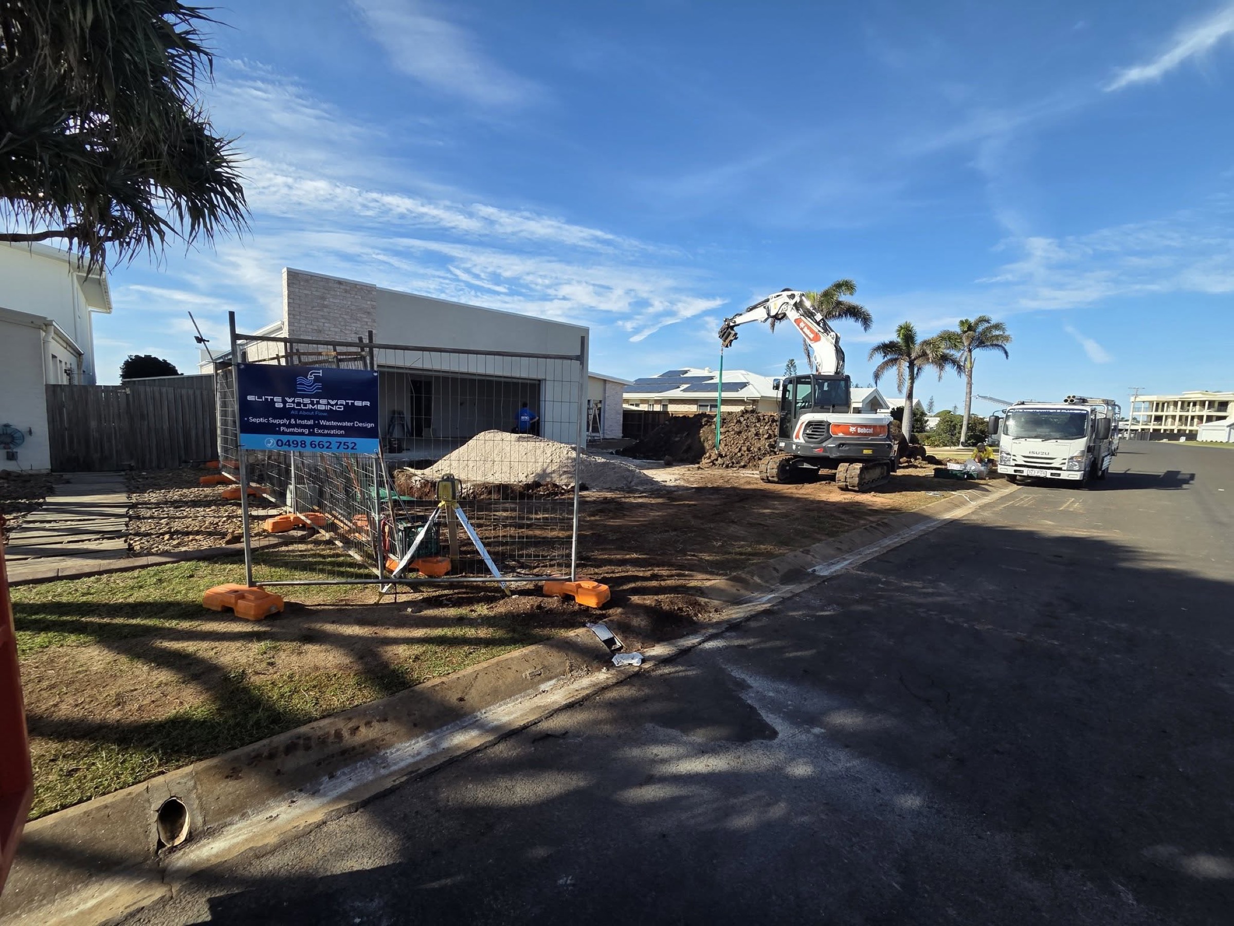 A commercial building site with a truck and excavator at work