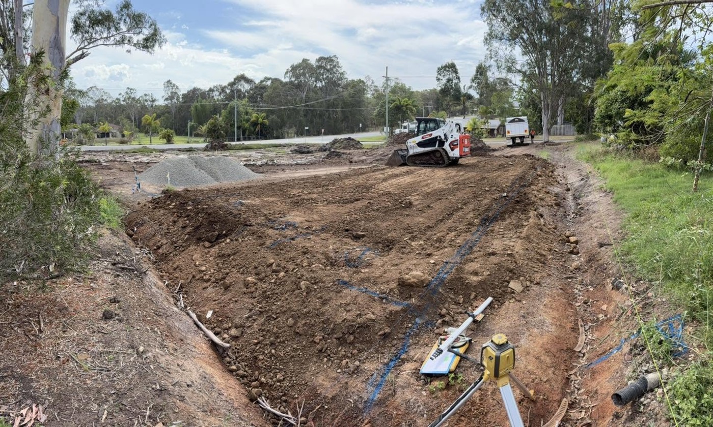 A cleared site with trenching and survey markers in place