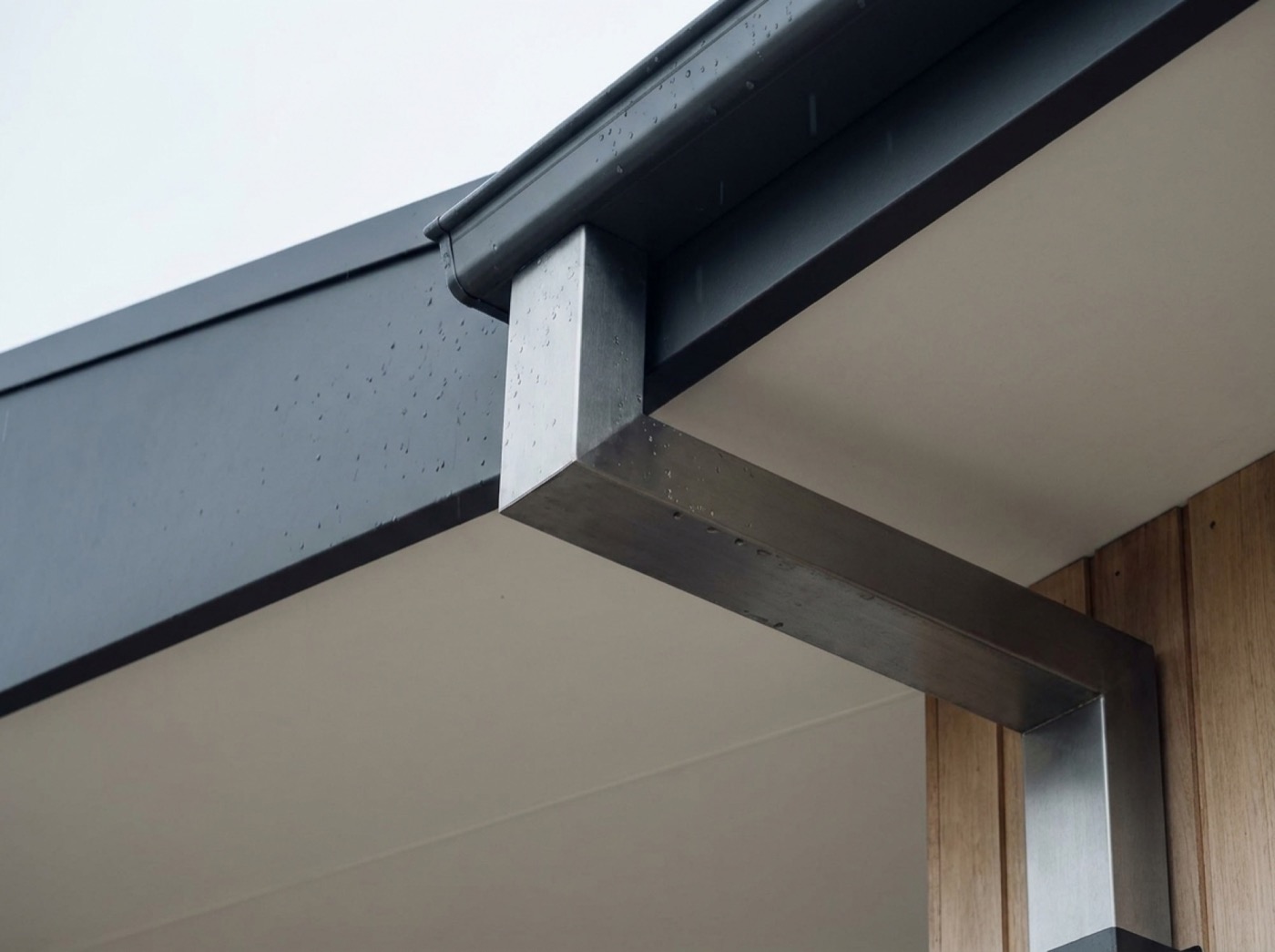 A gutter, fascia and downpipe outlet at the edge of a roof