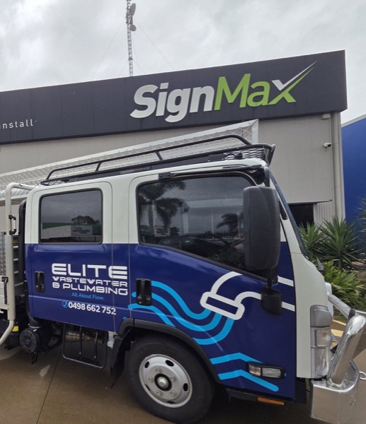 A branded Elite truck parked outside a signage workshop