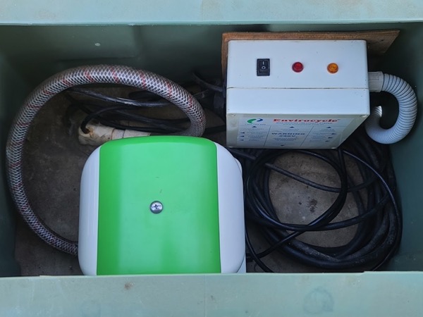 A wastewater control box and air blower inside an open cover