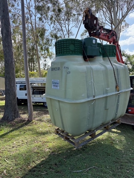 Treatment tanks strapped on a pallet beside a truck